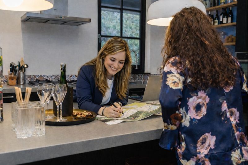 Receptiemedewerker legt een route uit op de kaart die op de balie ligt